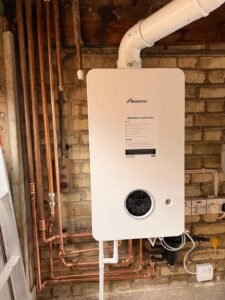 Worcester gas boiler installation with copper pipework on brick wall, London